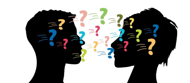 two silhouetted heads face each other, covered in colourful question marks